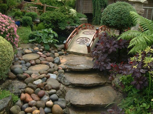 градински дизайн с много зелени растения и камъни