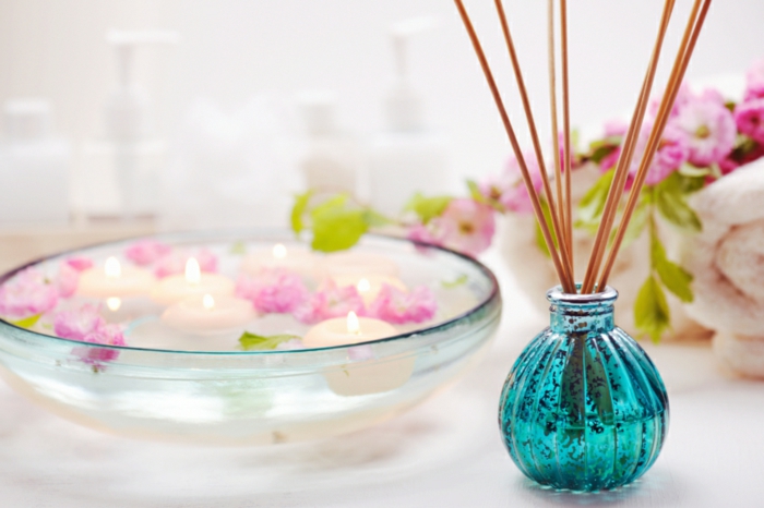 parfümös üveg, illatosító diffúzor, bambusz botok, úszó gyertyák, víz, virágok