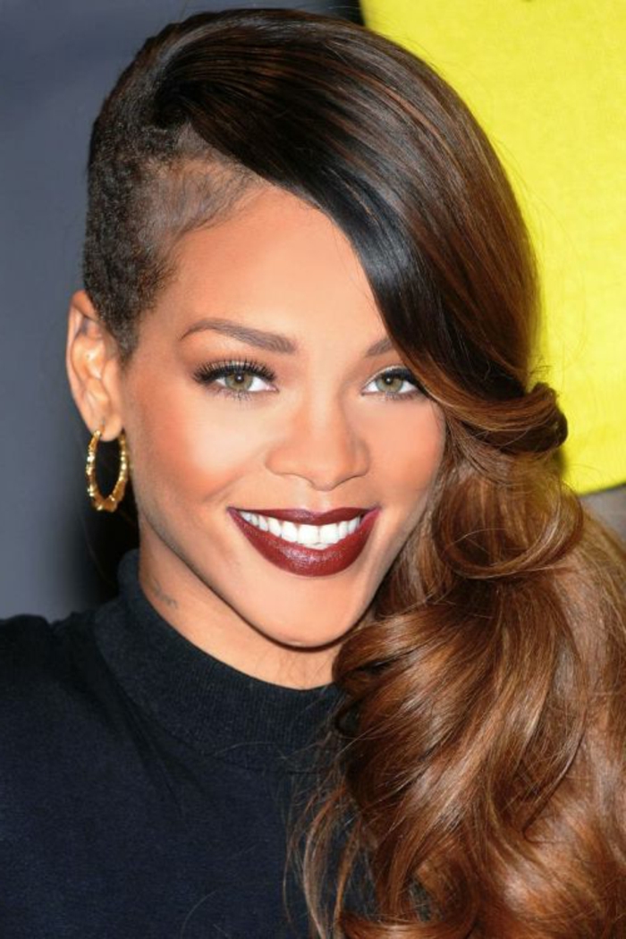 Hosszú barna haja az egyik oldalon, vörös rúzs és arany fülbevalók Rihanna képei