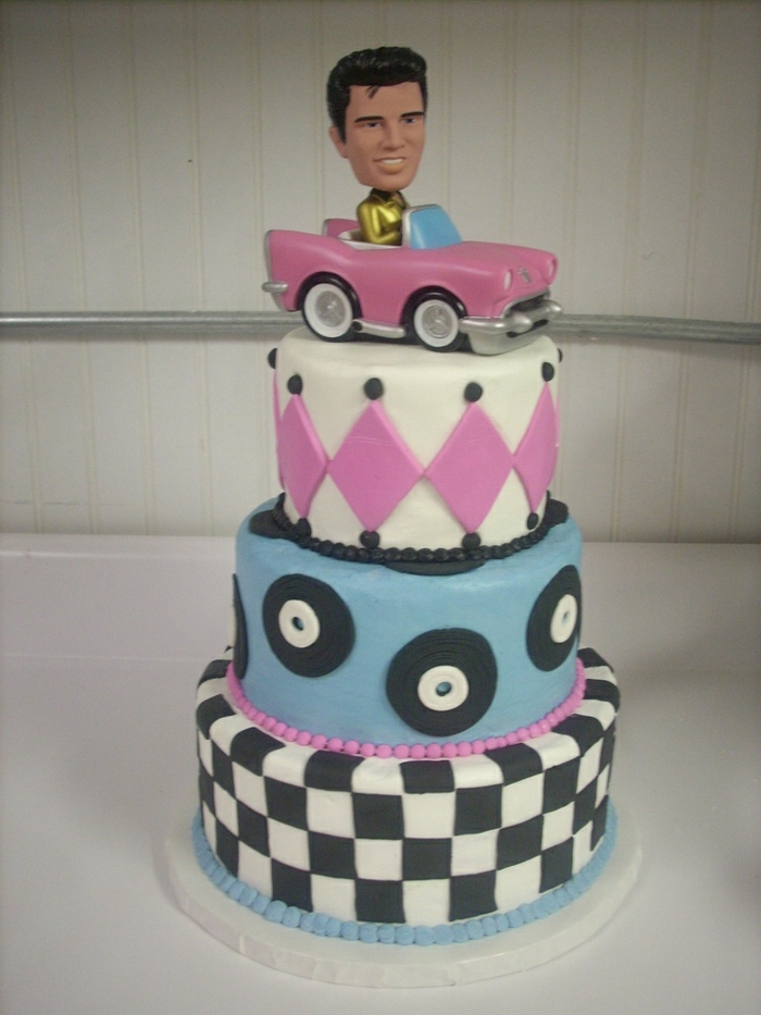 Елвис управлява розовата кола като украса на тортата - идеална за 50-те години