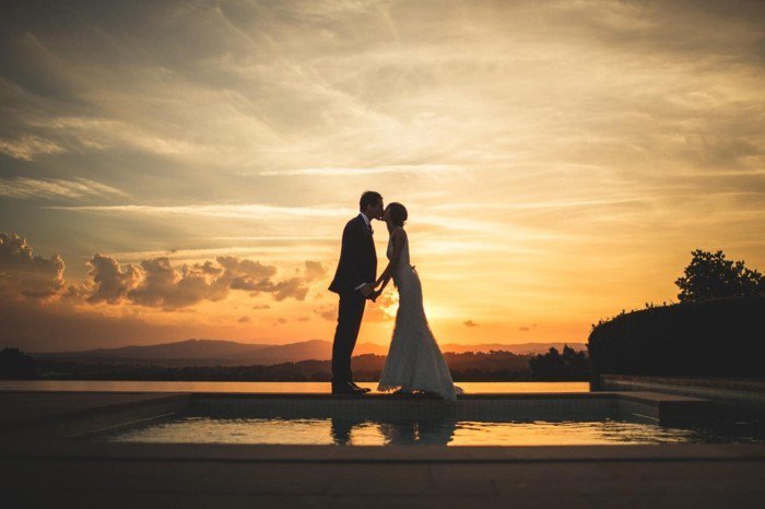 романтична представа и за сватба снимка булката и младоженеца се целуват по залез слънце