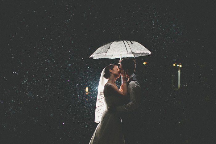 романтична сватба снимка булката и младоженеца целувка в дъжда