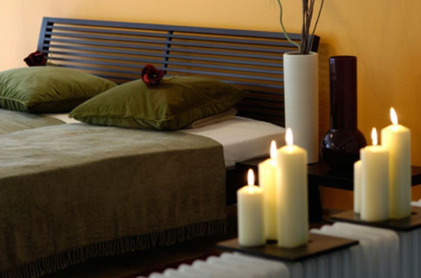 όμορφα κεριά δίπλα σε ένα μοντέρνο κρεβάτι