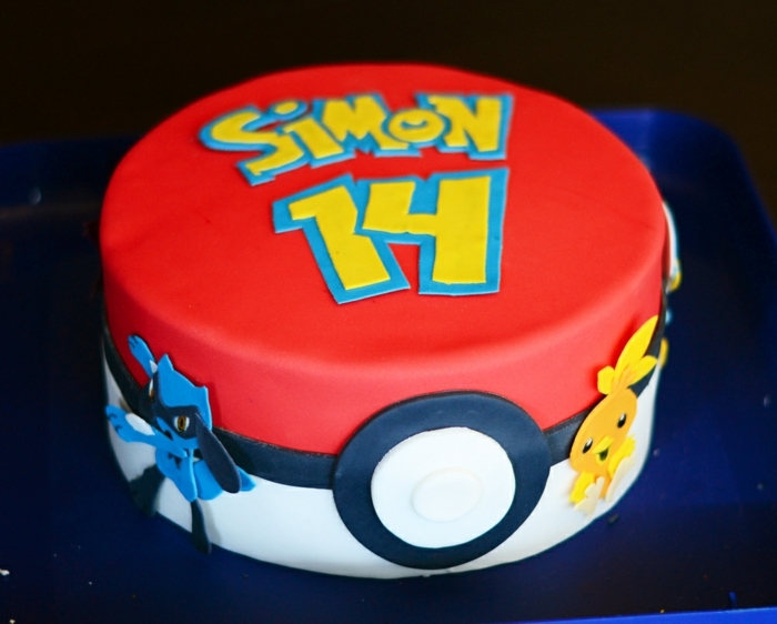 pokemon birthday kolač - ideja za veliku crvenu pokemonsku tortu koja izgleda kao crvena kugla, sa žutim naslovima i dva mala pokemonska stvorenja