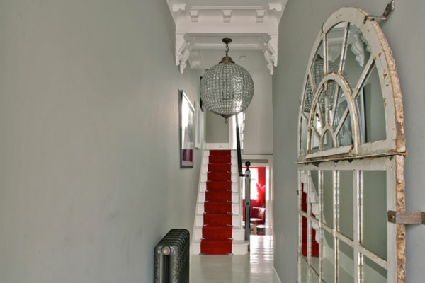 червен килим на стълби в коридора с оригинален дизайн на полилеи