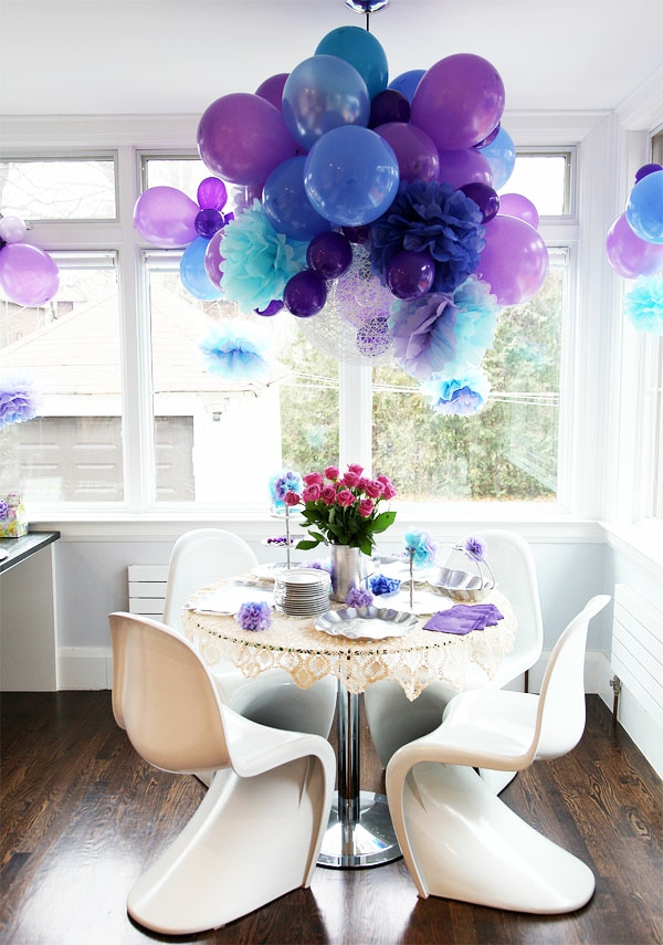 Балоните висят от тавана като декорация в малката стая - синьо и лилаво