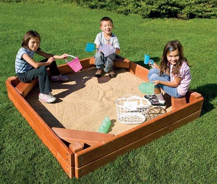 hiekkalaatikko-oma-rakentaa kolme lasta-hiekkalaatikossa