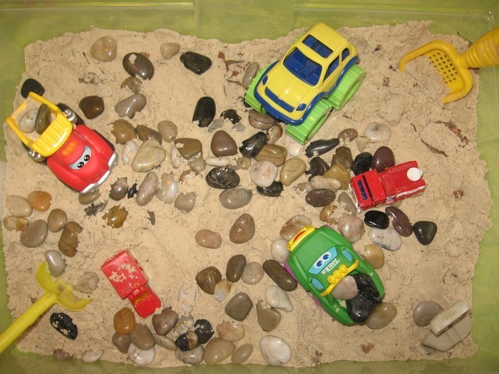 arenero-propio-acumulación de pequeñas piedras y juguetes