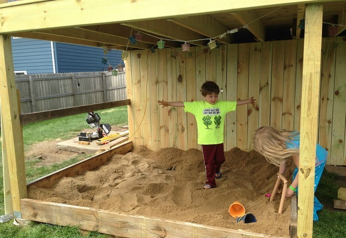 arenero-propia-construcción de dos-niños-jugar-en-la-caja de arena-cerrada