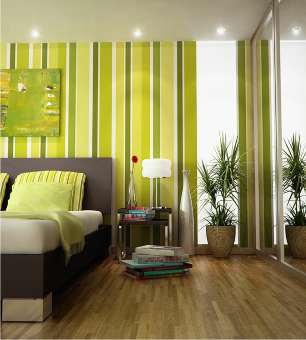 बेडरूम में दीवारों पर हरी फेंक तकिए और हरे रंग की रेखाएं