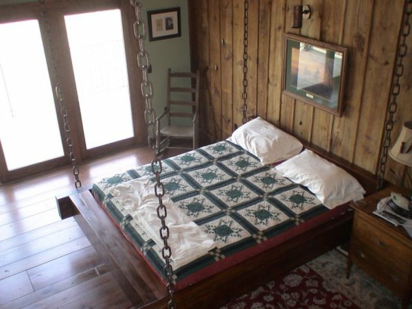 Viseći krevet u spavaćoj sobi s drvenim zidom