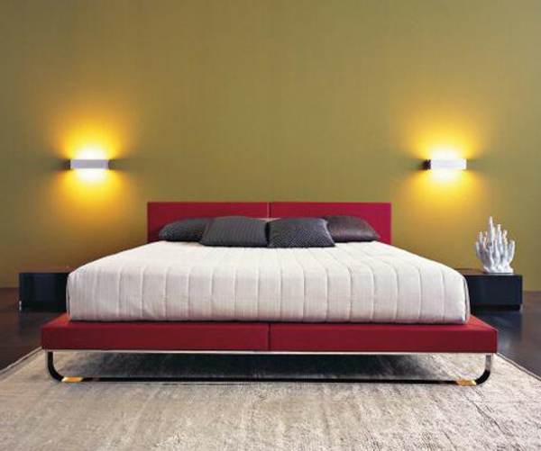 سرير جميل باللونين الأحمر والأبيض في غرفة النوم مع مصباحين جداريين