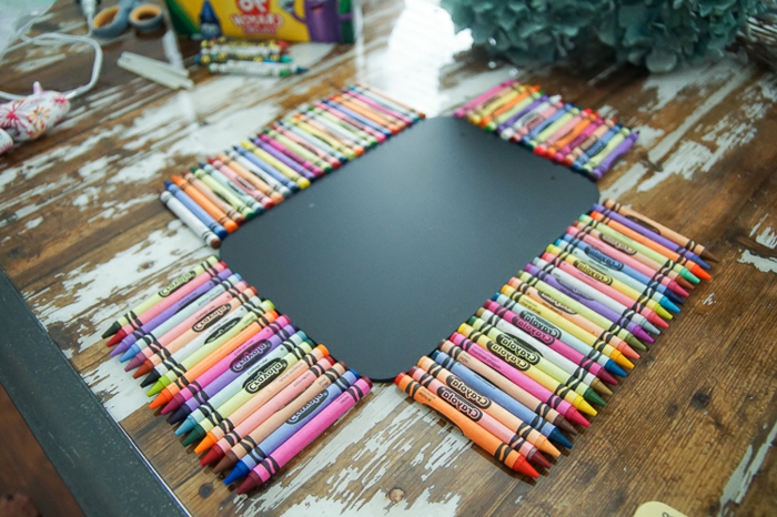 Aranyos iskolai kellékek - színes ceruzák, mint a szivárványok, fekete íróasztal körül