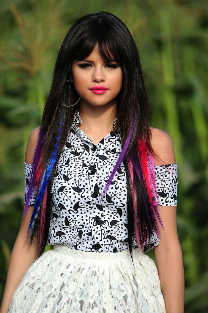 Selena Gomez színes szálakkal, hosszú haja a frufruval, fényes rúzs, fekete szempillaspirál