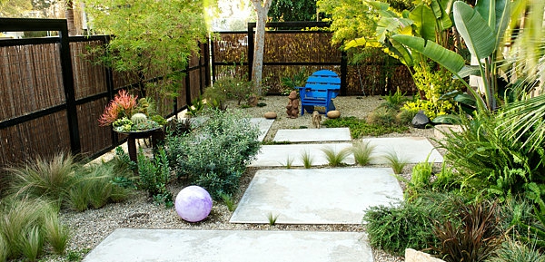 градина с бели каменни плочи и много зелени растения - ограда