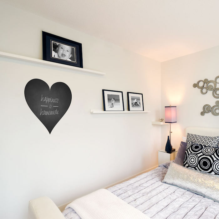 egy kis szív írólapból fehér feliratsal a hálószobában a falon, tele képekkel