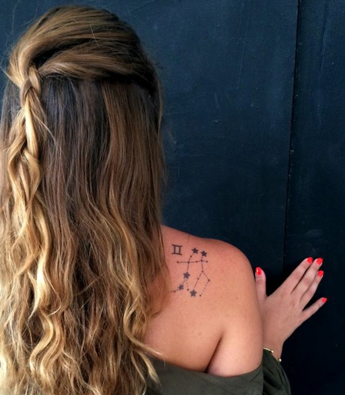 τατουάζ κίνητρα γυναίκα σγουρά μαλλιά ξανθιά πλεξούδα ζωδιακό τατουάζ στον ώμο πολύχρωμα νύχια μανικιούρ