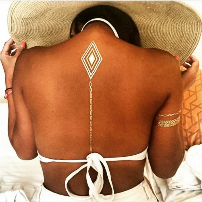 tetovaže žene pristojne tetovaža na stražnjem lanču u obliku bijelog kupaći kostim zlatne narukvice