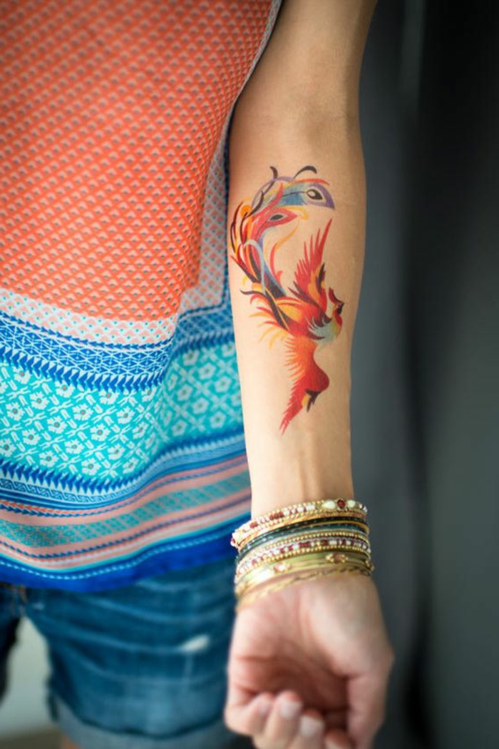 male tattoo ideje phönih ptica oslikana na ruku sa šarenim bojama mnoge šarene narukvice