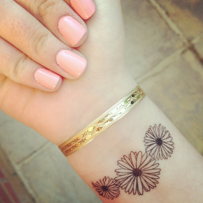 suptilna tetovaža dizajnirana u obliku tri lijepa cvjetova zlatna narukvica izvrsna manikura