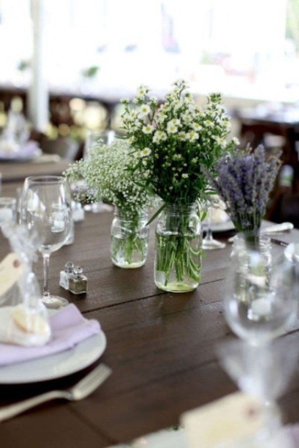 Koristele pöydällä erilaisia ​​ruokia ja monia kukkia modernilla tavalla