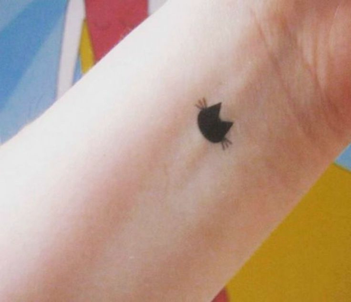 Aquí hay un pequeño tatuaje de gato negro en la mano: un gato negro con largas colas negras en su polla