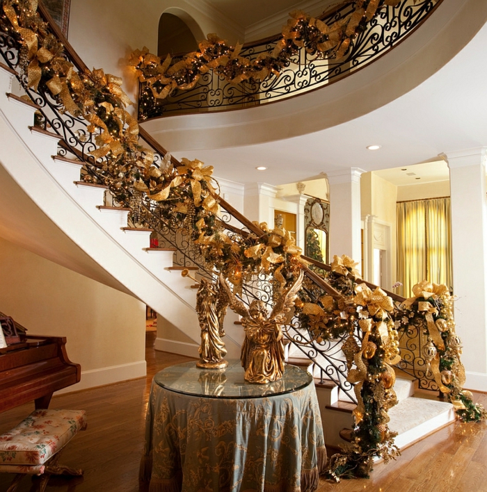 zlatno ukrašavanje stubišta za Božić s volumenima, bajkovitim svjetlima i anđelima na stolu