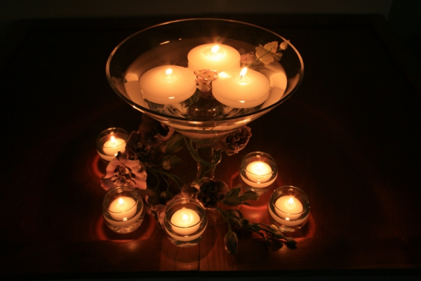 candelabros de vidrio de varios tamaños y velas pequeñas y más grandes - fondo negro