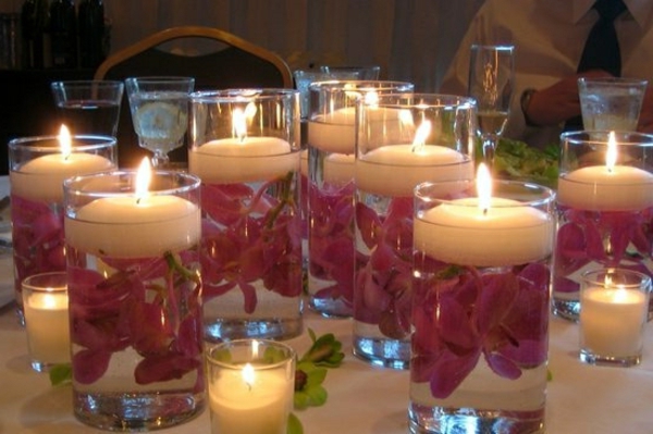 flores rosadas se desplazan en el agua en vasos como candelabros - decoración de velas hermosas