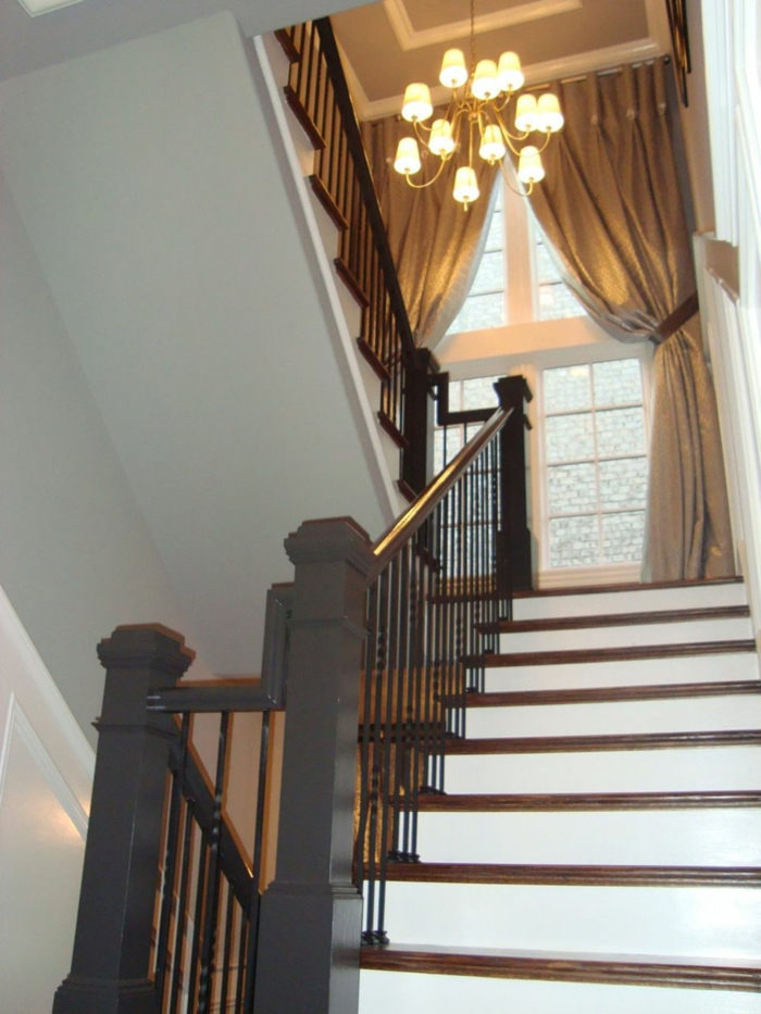 bijele stepenice i crne ograde, zavjese na prozoru - ukrašavanje stubišta