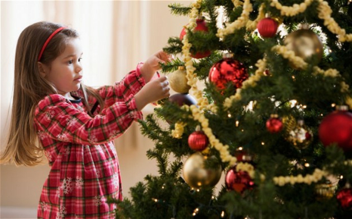 Božićno drvce-uređenje-malo-djevojka-i-vijenac