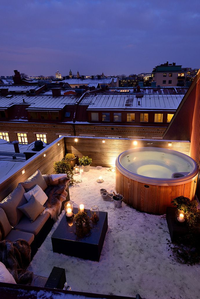 terrasse sur le toit du bain à remous dans les bougies d'hiver