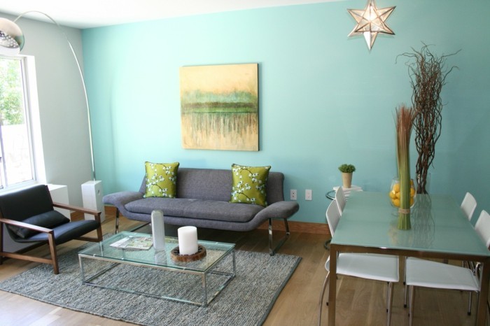 Цвят на дизайн-дневна килим-стъклена маса Свещи-дюшеме и сиво-зелен диван-възглавници-растение автомобилната-платно-обикновена лампа-светло синьо-стена-черно кожено кресло