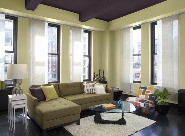 Olohuone sisätiloissa, jossa lasinen pesäpöytä ja tuoreet värit seinille
