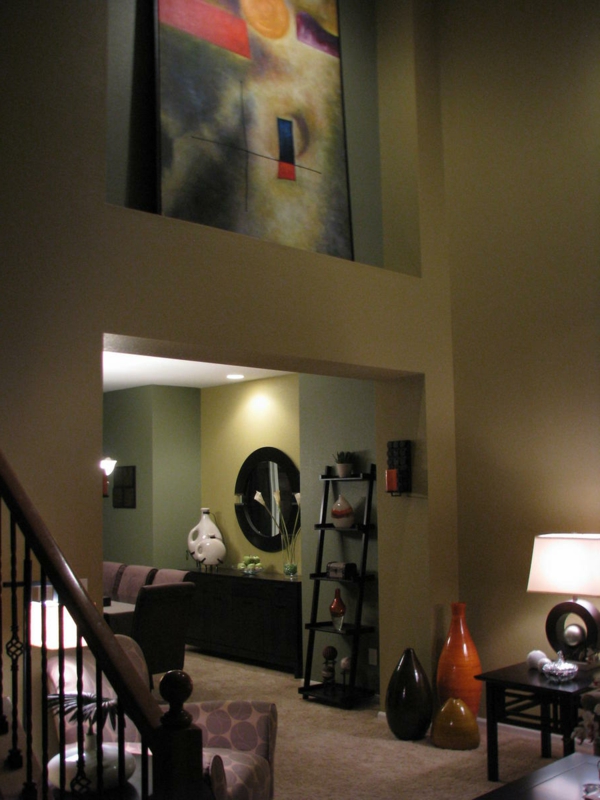 غرفة معيشة مزودة بمعدات مبتكرة - جدران مشرقة ولوحات كبيرة