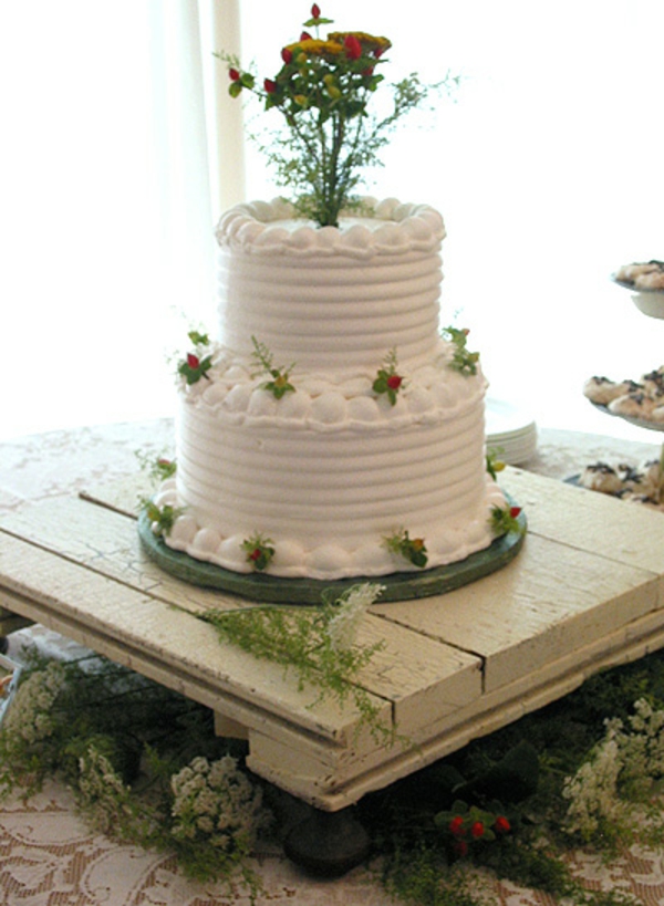 celebración de la boda de madera - pastel blanco con decoración de flores