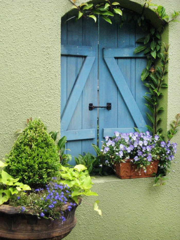 hermosas persianas azules pared verde flor