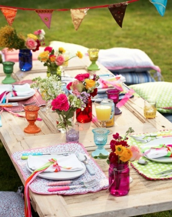 gyönyörű nyári asztali dekoráció kreatív ötlet színes virágok és dobja párnák a padlón
