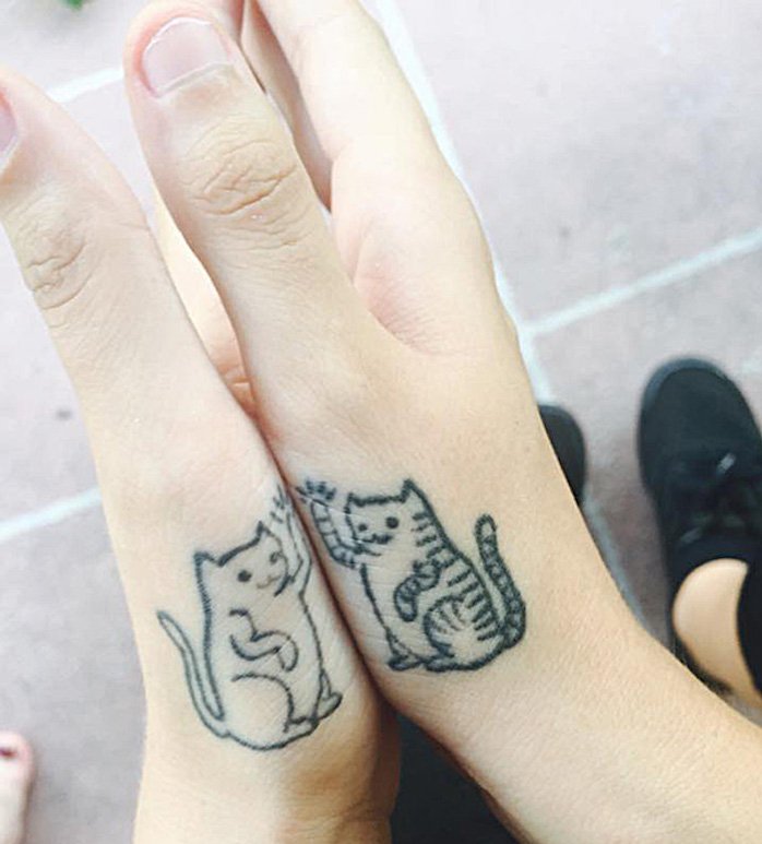 Nämä ovat kaksi pientä mustata kissaa ja kaksi kättä - hienoja ideoita tatuoinnille